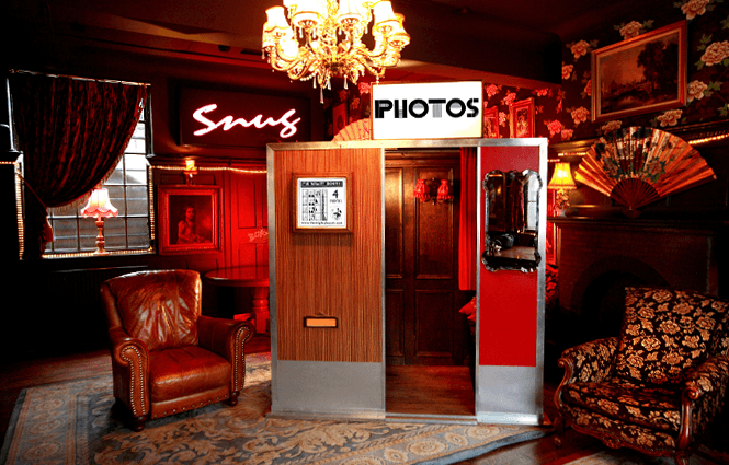 Guests celebrating in front of a Mighty Booth backdrop